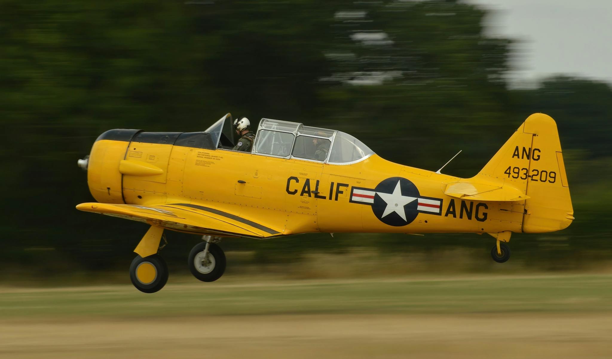 A classic yellow aircraft taking off at an airfield in Headcorn, England. Captured for aviation enthusiasts.